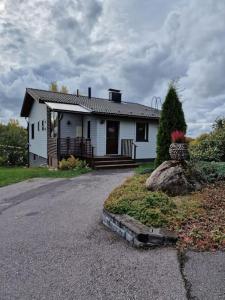 een wit huis met een veranda en een oprit bij Villa Silve, yhden makuuhuoneen omakotitalo. in Lohja