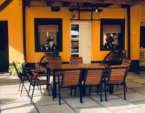 una mesa de madera y sillas frente a una pared amarilla en Casa Ardeleneasca, en Sebeşu de Sus