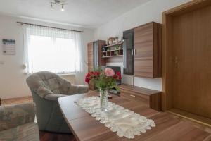 a living room with a vase of flowers on a table at Bungalow Krebs in Hasselfelde