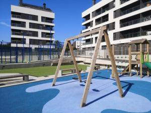 une aire de jeux avec balançoire située en face d'un bâtiment dans l'établissement Casa de Olga & Jorge, à Luanco