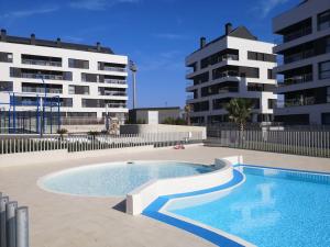 a swimming pool in front of two tall buildings at Casa de Olga & Jorge in Luanco