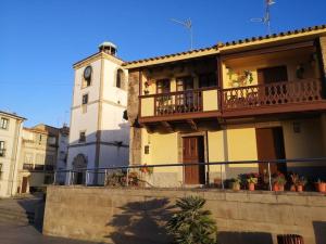 un bâtiment avec une tour d'horloge dans une ville dans l'établissement Casa de Olga & Jorge, à Luanco