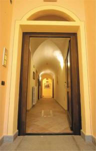 einen Flur in einem Gebäude mit einem Flur, der zu einer Tür führt in der Unterkunft Casa Vacanze Provenzale in Torre Pellice
