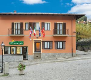 a orange building with flags in front of it at Casa Vacanze Provenzale in Torre Pellice