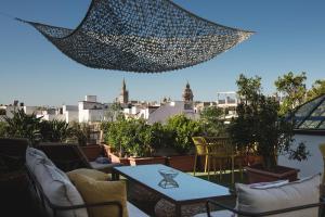 un patio con sillas y una mesa en el techo en La Casa del Maestro Boutique, en Sevilla