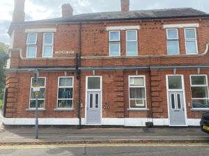 a red brick building with white windows and doors at Midland Apartments- one bedroom in Leicester