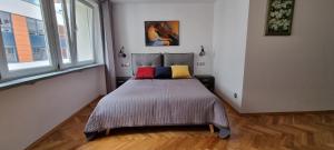 1 dormitorio con 1 cama con 2 almohadas coloridas en Przytulnie w samym centrum Warszawy, en Varsovia
