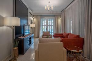 a living room with a couch and a tv at Alvanti Residences in Accra