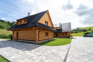 a log cabin with a car parked in front of it at Chatky JOSU in Zuberec
