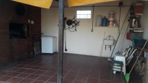 garaje con puerta blanca y suelo de baldosa en casa de campo a 40 km de Rosario 