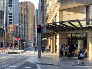 a group of people walking on a city street at Huge Exec Apartment -Fantastic CBD Location B21001 in Sydney