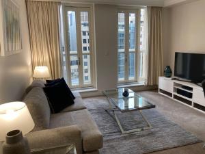 een woonkamer met een bank en een tv bij Huge Exec Apartment -Fantastic CBD Location B21001 in Sydney