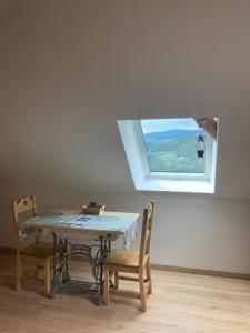 a table and chairs in a room with a window at Le nid du Kaloui in Fréland