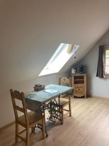 a dining room with a table and a skylight at Le nid du Kaloui in Fréland +37 photos