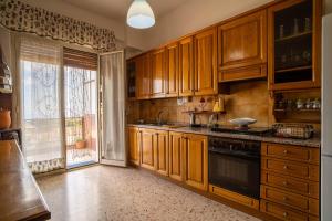 une cuisine avec des placards en bois et une grande fenêtre dans l'établissement Casa Venera sull'etna, à Nicolosi