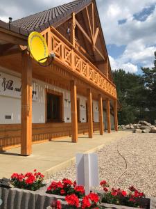 a large wooden building with a yellow frisbee on it at Swornegacie Villa nad Zbrzycą in Wielkie Zanie