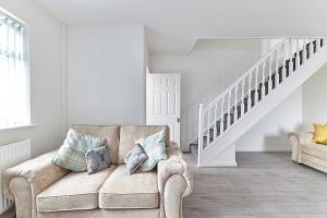 a living room with a couch and a staircase at Gatacre House - Stylish 3 bed house, sleeps 7 in Blythe