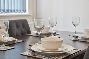 a table with wine glasses and a bowl on it at Gatacre House - Stylish 3 bed house, sleeps 7 in Blythe