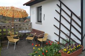 a patio with a table and chairs and an umbrella at Ferienhaus Harztraum in Sorge