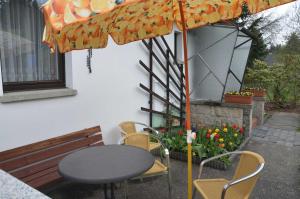 a table and chairs and an umbrella on a patio at Ferienhaus Harztraum in Sorge