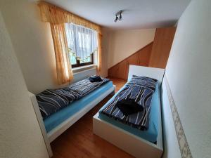 - une petite chambre avec 2 lits et une fenêtre dans l'établissement Ferienhaus Döring, à Hasselfelde