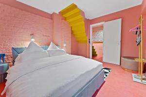 a bedroom with a white bed and a colorful wall at Crazy 44sqm 3room maisonette apt Near center in Berlin