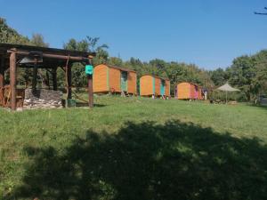 a row of colorful tents in a field at Poiana Stelelor 
