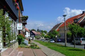 a street in a small town with houses and cars at Ferienhaus Müller in Benneckenstein