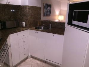 a kitchen with white cabinets and a sink and a microwave at Heart of SYDNEY CBD - studio apartment B412 in Sydney