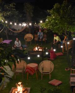un grupo de personas sentadas alrededor de un fuego en un patio por la noche en Alpamayo Casa Hotel - Restaurante en Yungay
