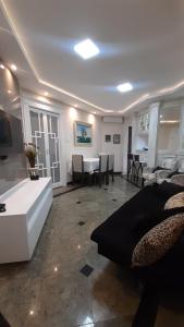 een woonkamer met een bank en een tafel bij Lindo Flat no Gonzaga, com GARAGEM e PISCINA in Santos