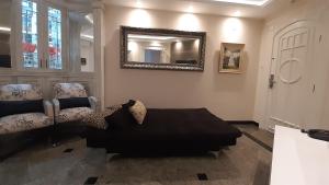 ein Wohnzimmer mit einem Sofa und einem Spiegel in der Unterkunft Lindo Flat no Gonzaga, com GARAGEM e PISCINA in Santos