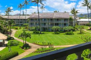 an exterior view of a large building with a garden at Islander on the Beach 333 in Kapaa