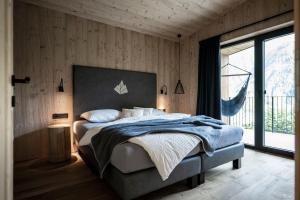 a bedroom with a bed and a large window at Stelza Nature Chalet in Val di Vizze