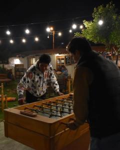 dos hombres parados junto a una mesa de juego gigante en Alpamayo Casa Hotel - Restaurante, en Yungay