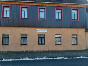 un edificio con finestre rosse e tetto blu di Ferienwohnung "Das alte E-Werk" mit Kamin a Elend