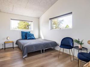 een slaapkamer met een bed en 2 ramen bij Holiday home Oksbøl LXXXIV in Oksbøl