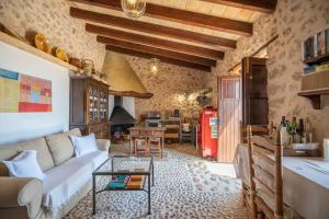 un soggiorno con un divano e un tavolo di CAN PULIT - finca romántica para 2 con piscina y vistas en Selva Mallorca a Selva
