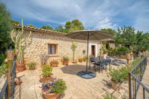 un patio con un tavolo e un ombrellone di CAN PULIT - finca romántica para 2 con piscina y vistas en Selva Mallorca a Selva
