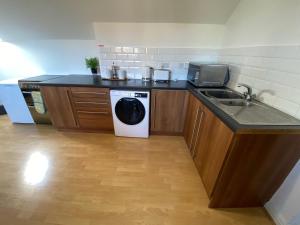 a kitchen with a sink and a washing machine at Modern Spacious Flat In Ipswich - Sleeps 6 - Parking in Freston