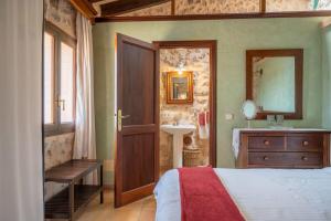 una camera da letto con un letto, un lavandino e uno specchio di CAN PULIT - finca romántica para 2 con piscina y vistas en Selva Mallorca a Selva Altre 23 foto