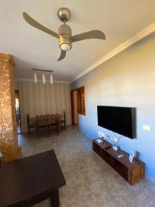 uma sala de estar com uma ventoinha de tecto e uma televisão de ecrã plano em El Olivar Fuerteventura Holidays em Puerto del Rosario