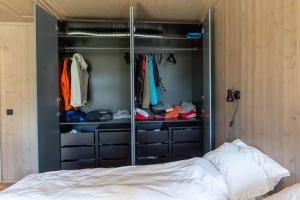 einen begehbaren Kleiderschrank mit einem Bett in einem Zimmer in der Unterkunft Ny leilighet på Kvitfjell Vest. Ski inn/ut in Favang