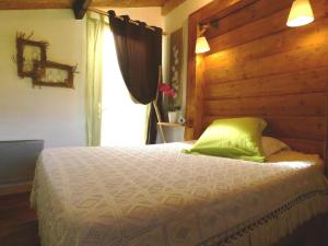 a bedroom with a bed with green pillows and a window at Gîte l'Atelier Bois in Gaillères