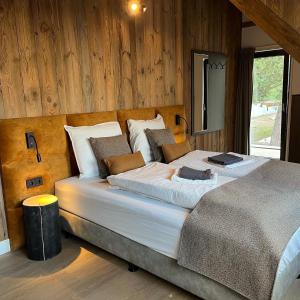 a large bed in a room with wooden walls at DualPark Afritz am See in Scherzboden
