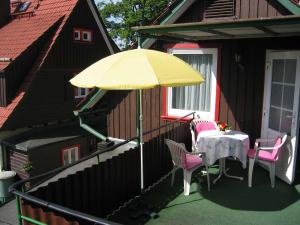 un patio con una mesa y una sombrilla amarilla en Ferienwohnung Lippe en Elbingerode