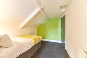 sypialnia z zielonymi i białymi ścianami oraz łóżkiem w obiekcie Maddison House, Beautiful new renovated 5bed house w mieście Blythe