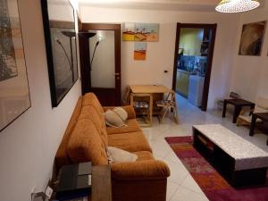 - un salon avec un canapé brun et une table dans l'établissement Residenza L’Elicriso - Assemini, à Assemini