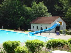 a blue slide in a swimming pool with a house at Ferienwohnung Walpurga in Elend