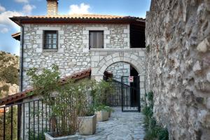 an entrance to a stone house with a gate at Archontiko Deligianni in Dhimitsana